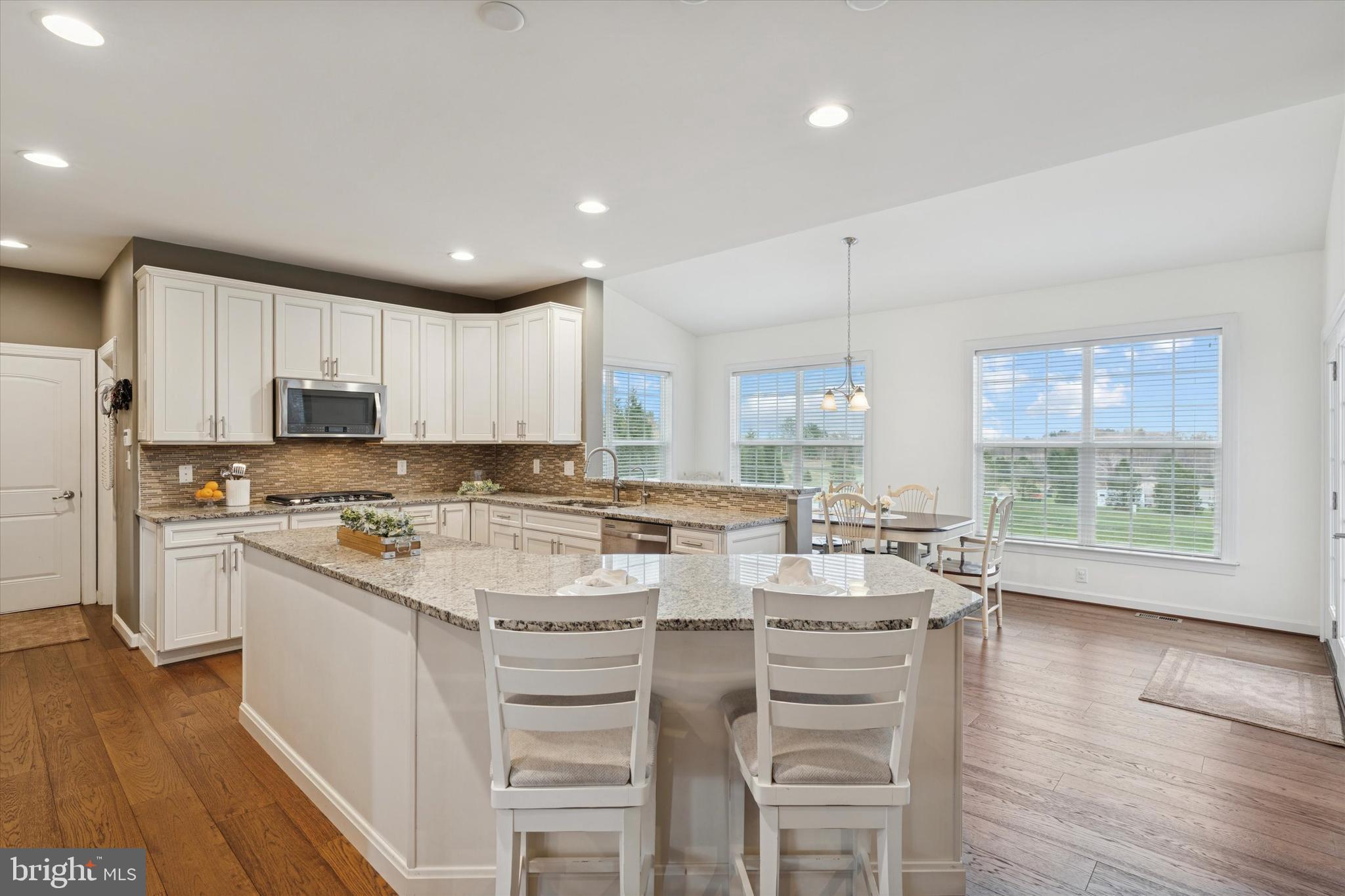 1392 Hickory Hill Road Chadds Ford, PA 19317 - Photo 9 of 35 a kitchen with kitchen island granite countertop a stove a sink a refrigerator and white cabinets with wooden floor