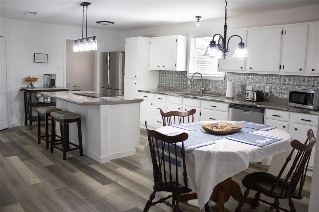 214 County Road 2147 Quitman, TX 75783 - Photo 12 of 38 a kitchen with stainless steel appliances granite countertop a kitchen island a stove a table and chairs in it