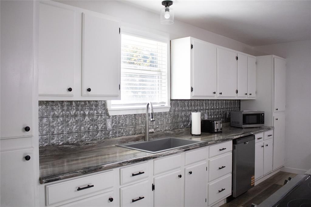 214 County Road 2147 Quitman, TX 75783 - Photo 14 of 38 a kitchen with granite countertop a sink window and cabinets