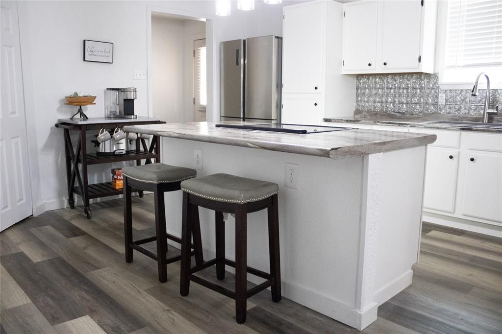 214 County Road 2147 Quitman, TX 75783 - Photo 18 of 38 a kitchen with stainless steel appliances a table and chairs in it
