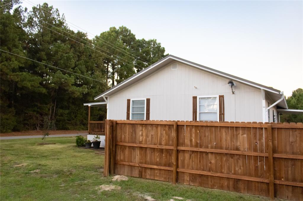 214 County Road 2147 Quitman, TX 75783 - Photo 35 of 38 a view of a backyard with wooden fence and large trees