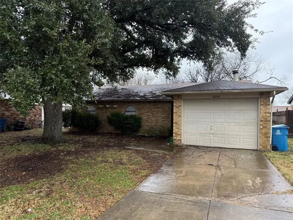 a view of a stone house with large tree
