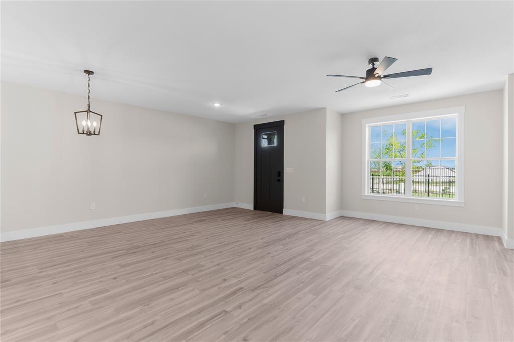 1650 Palladio Loop, Unit 2 Princeton, TX 75407 - Photo 10 of 14 Spacious room featuring wood-finish flooring, a contemporary ceiling fan, and a four-light pendant fixture