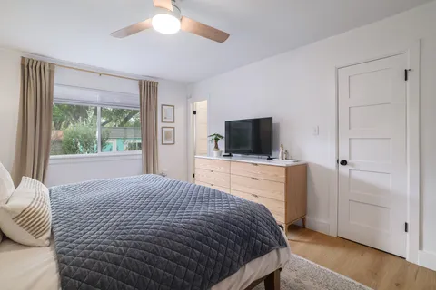 a bedroom with a large bed and a flat tv screen