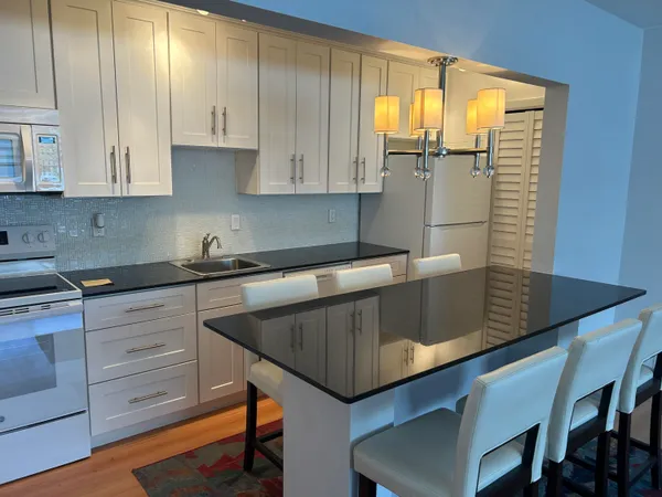 a kitchen with stainless steel appliances a sink a window and cabinets
