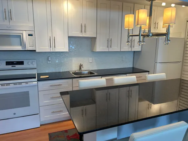 a kitchen with stainless steel appliances granite countertop a sink a stove and cabinets