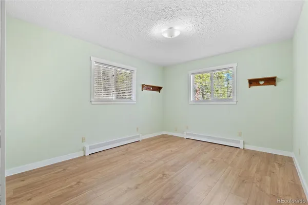 a view of an empty room with wooden floor