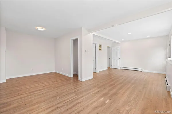an empty room with wooden floor and window