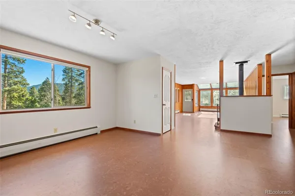 a kitchen with stainless steel appliances granite countertop a refrigerator a sink a stove a dining table and chairs with wooden floor