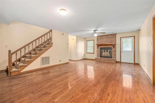 a view of empty room with wooden floor and fireplace