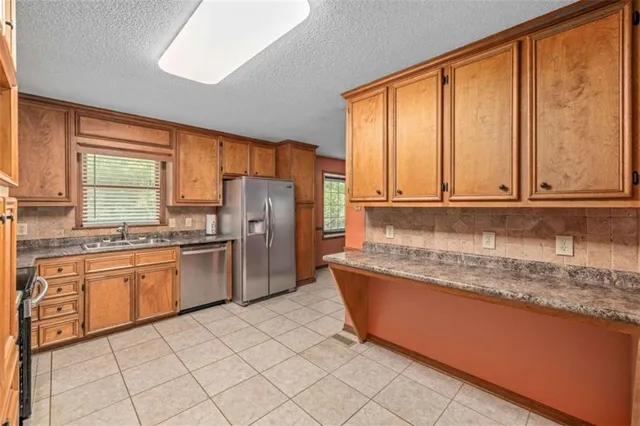 a kitchen with stainless steel appliances granite countertop a refrigerator sink and cabinets