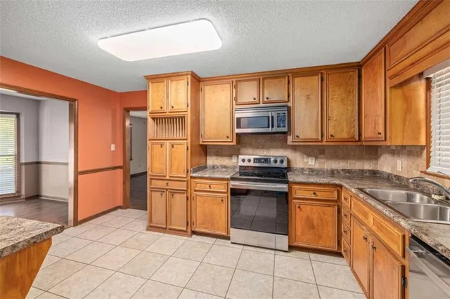 a kitchen with stainless steel appliances granite countertop a stove a sink and a refrigerator