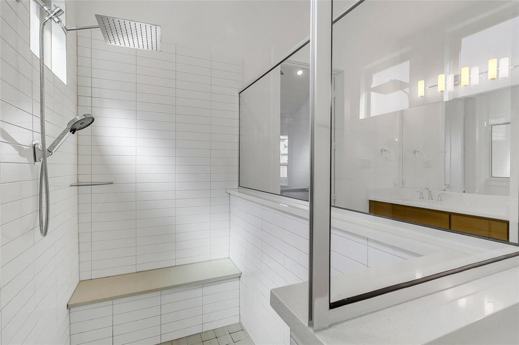 1241 Lupine Road Prosper, TX 75078 - Photo 22 of 38 Walk-in shower with white subway tile, rain shower head, handheld sprayer, built-in bench, and clear glass enclosure
