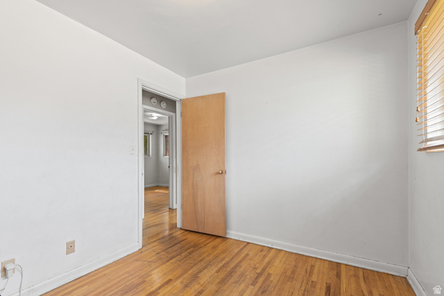 542 East 3400th Street North Provo, UT 84604 - Photo 24 of 39 Room with wood-finish flooring, a light wood door, and a window with wood blinds