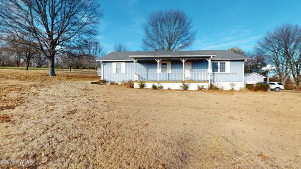 a front view of a house with a yard covered with snow