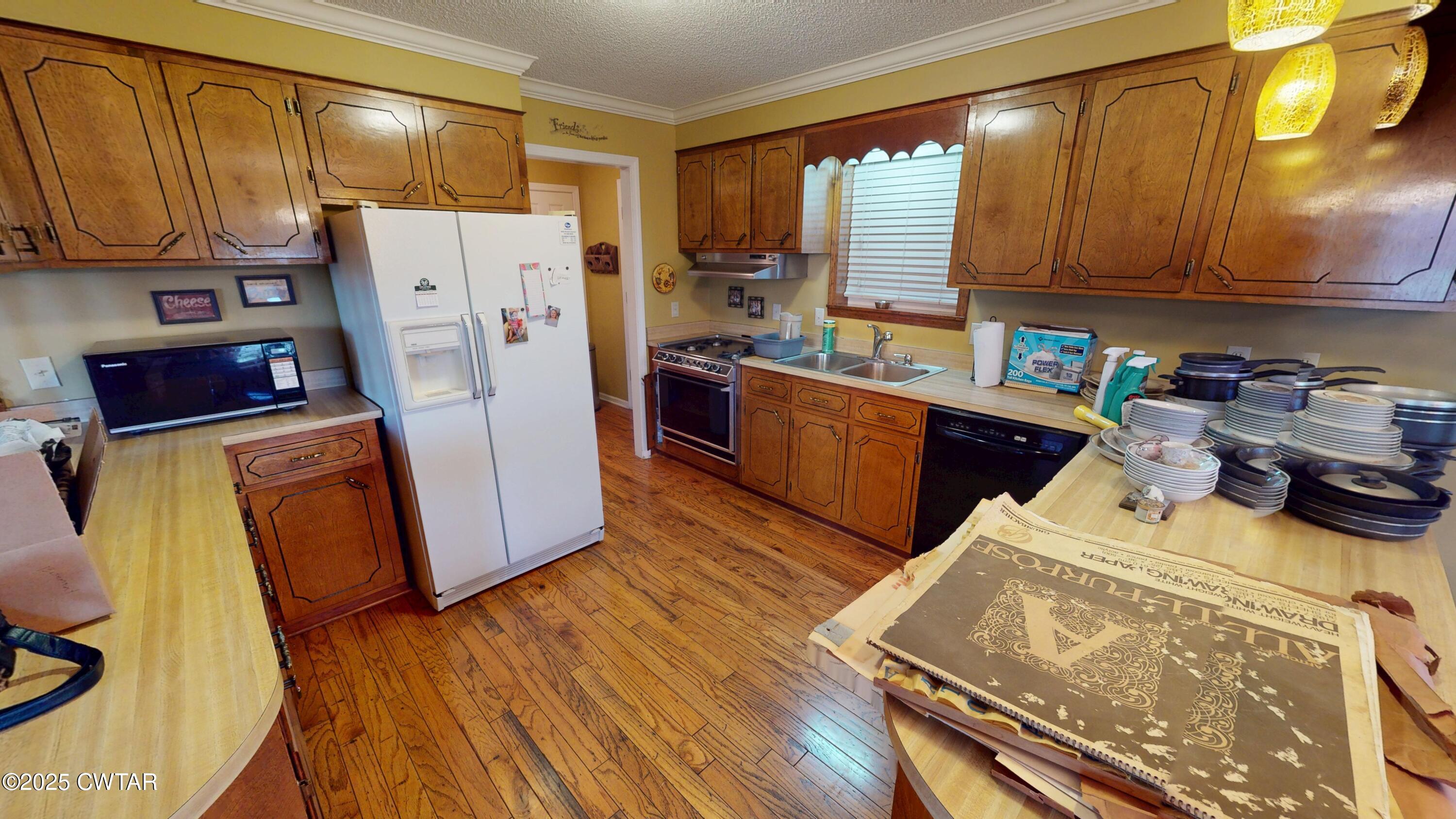4960 Upper Finley Road Dyersburg, TN 38024 - Photo 9 of 39 a kitchen with a refrigerator a stove top oven and wooden floors