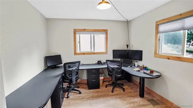 a view of a workspace with furniture and a window