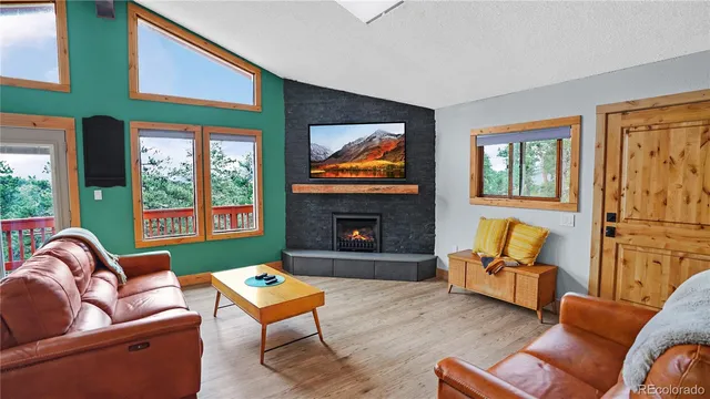 a living room with furniture a fireplace and next to windows