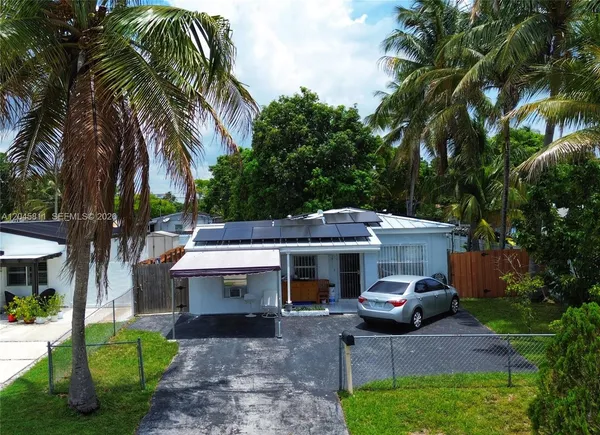 a view of a house with backyard and a tree