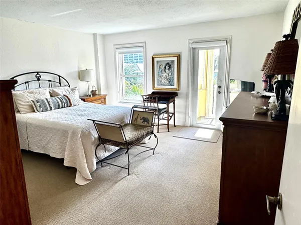 a bedroom with a bed dresser and a flat tv screen