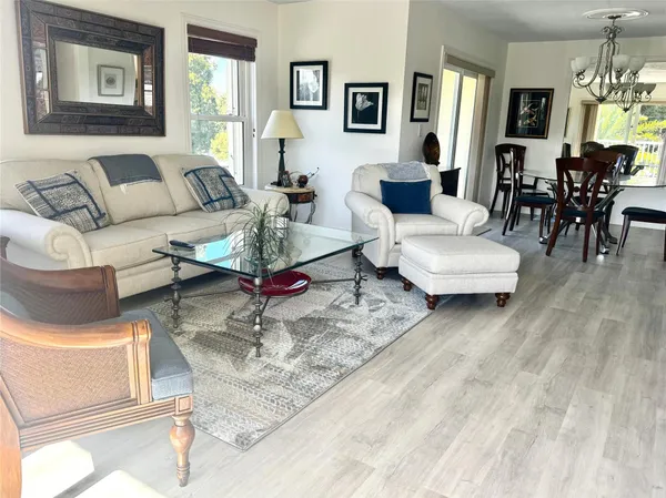 a view of a dining room with furniture a chandelier and wooden floor