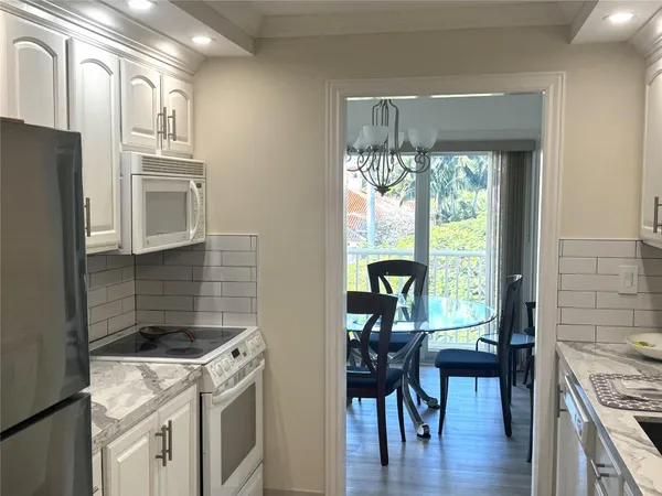a kitchen with stainless steel appliances granite countertop a refrigerator and a sink