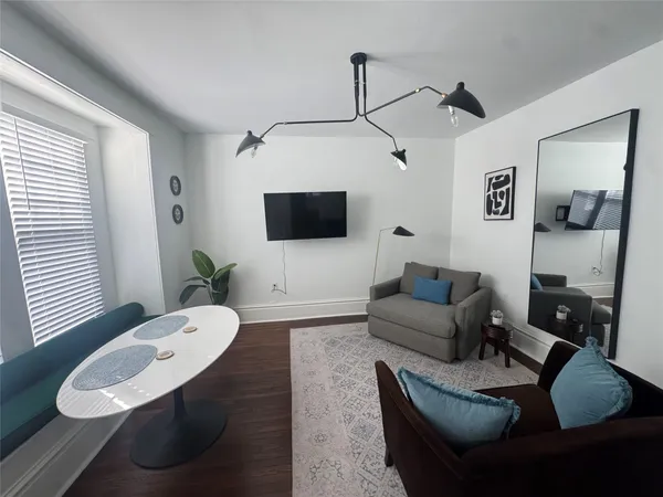 a living room with furniture a window and a flat screen tv