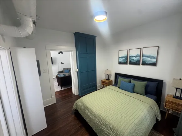 a bedroom with a bed and wooden floor