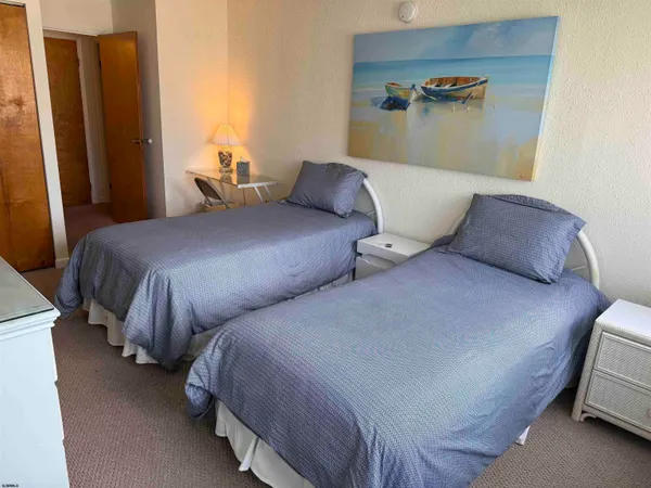 a bedroom with two beds and wooden floor