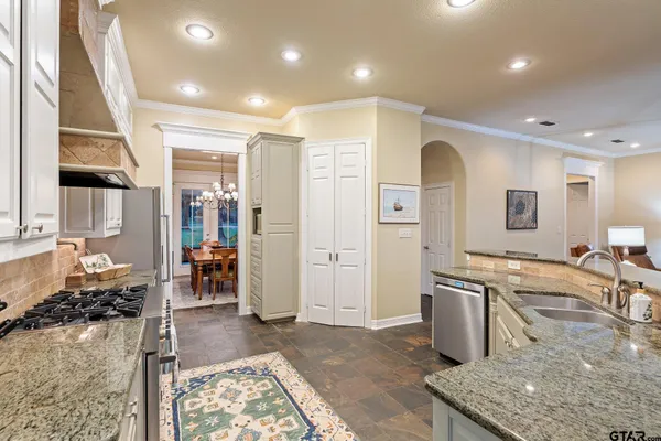 a kitchen with stainless steel appliances granite countertop a sink stove and refrigerator
