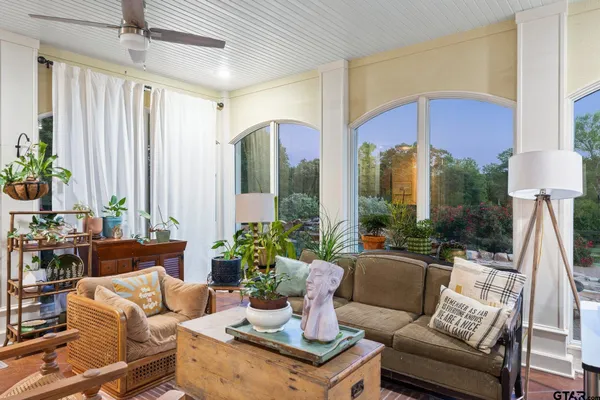 a living room with furniture potted plant and a large mirror