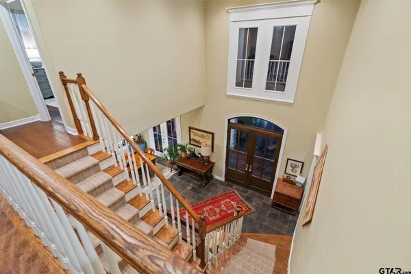a kitchen with stainless steel appliances granite countertop a refrigerator a stove and white cabinets with wooden floor