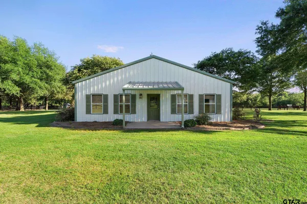 a kitchen with stainless steel appliances granite countertop a stove top oven a sink dishwasher a dining table and chairs with wooden floor