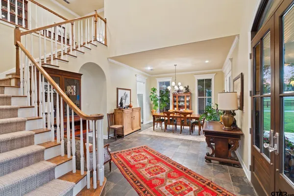 a living room with stairs and a rug