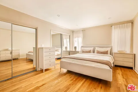 a spacious bedroom with a bed and wooden floor