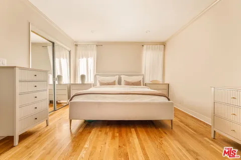 a spacious bedroom with a bed and a dresser