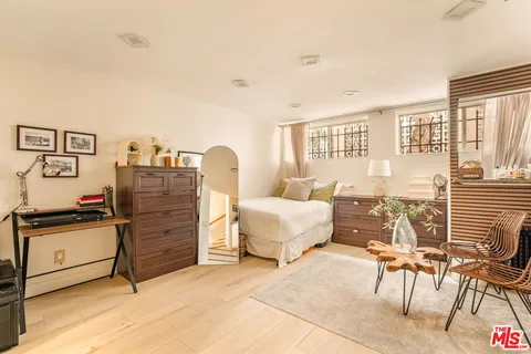 a bedroom with furniture and a large window