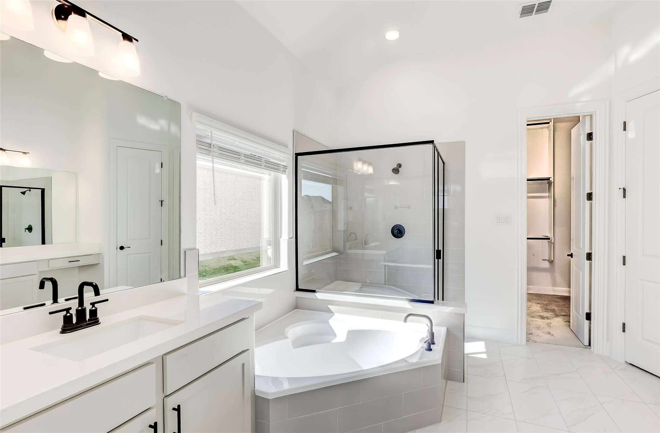 920 Old Gdn Road Leander, TX 78641 - Photo 19 of 39 Bathroom featuring a stall shower, a spacious closet, vanity, a garden tub, and recessed lighting