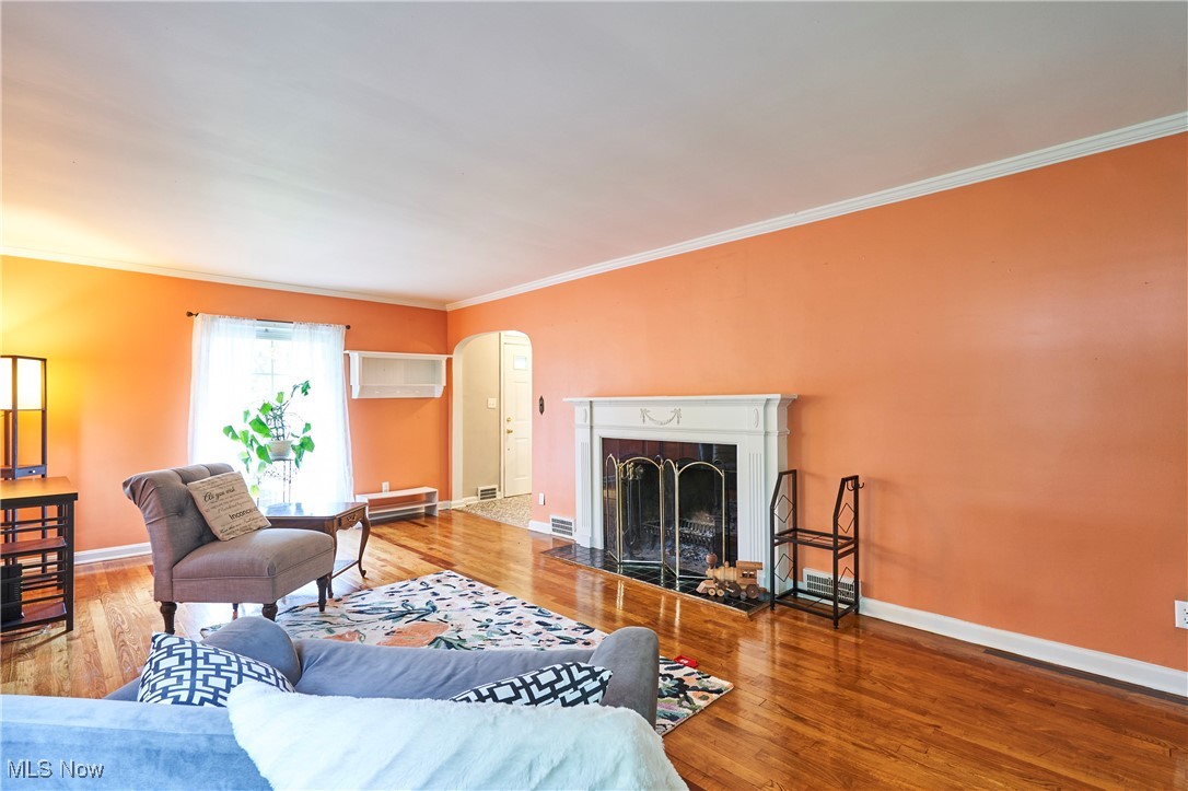 210 Hilen Road Akron, OH 44333 - Photo 6 of 27 Living room with arched walkways, refinished wood floors, crown molding, wood burning fireplace
