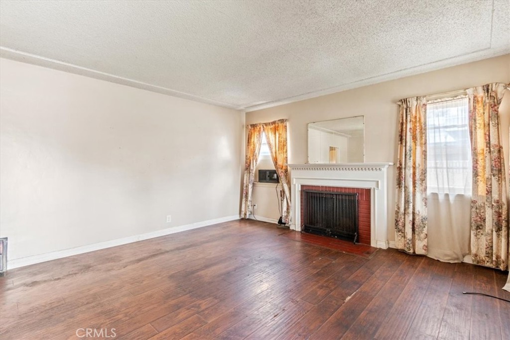 5929 Norwalk Boulevard Whittier, CA 90606 - Photo 14 of 33 an empty room with wooden floor fireplace and windows