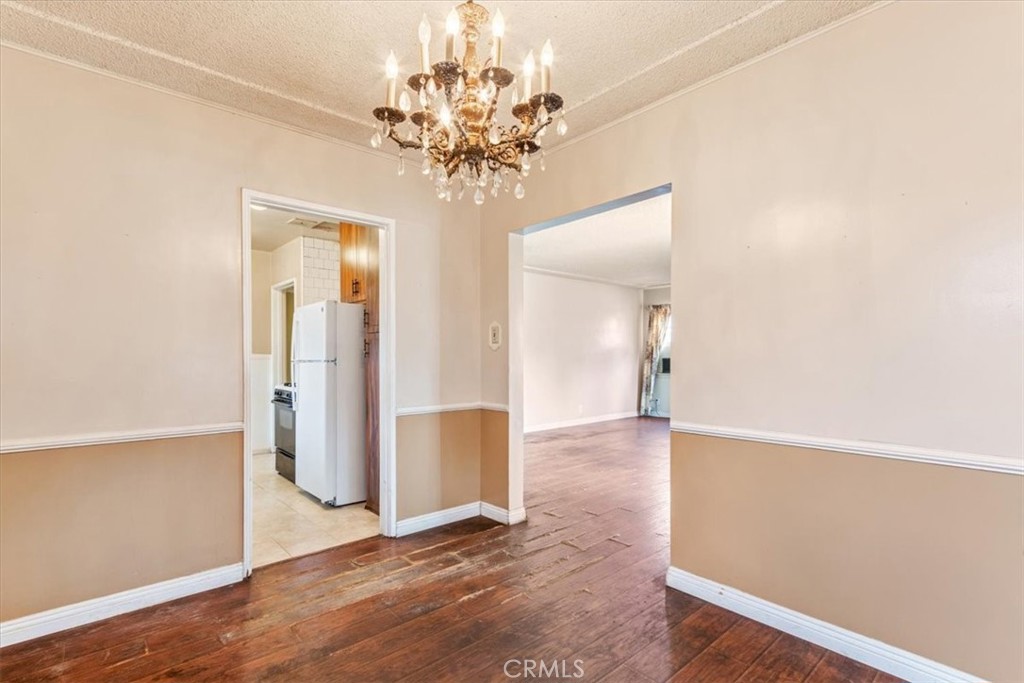 5929 Norwalk Boulevard Whittier, CA 90606 - Photo 25 of 33 an empty room with wooden floor and chandelier