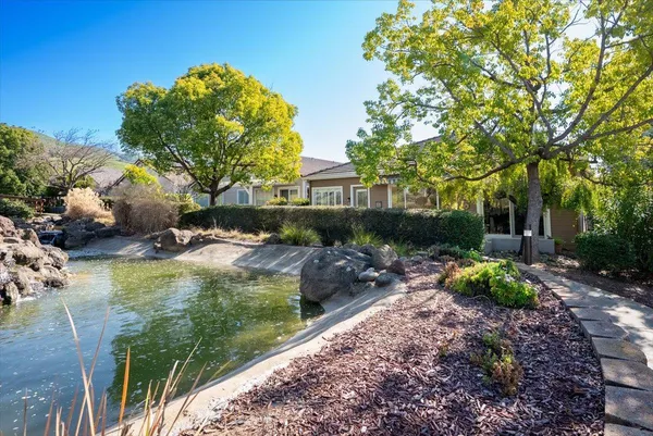 a view of a house with backyard sitting area and garden
