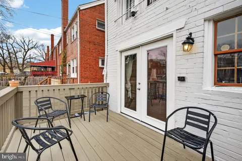 a view of a brick house with table and chairs and wooden floor