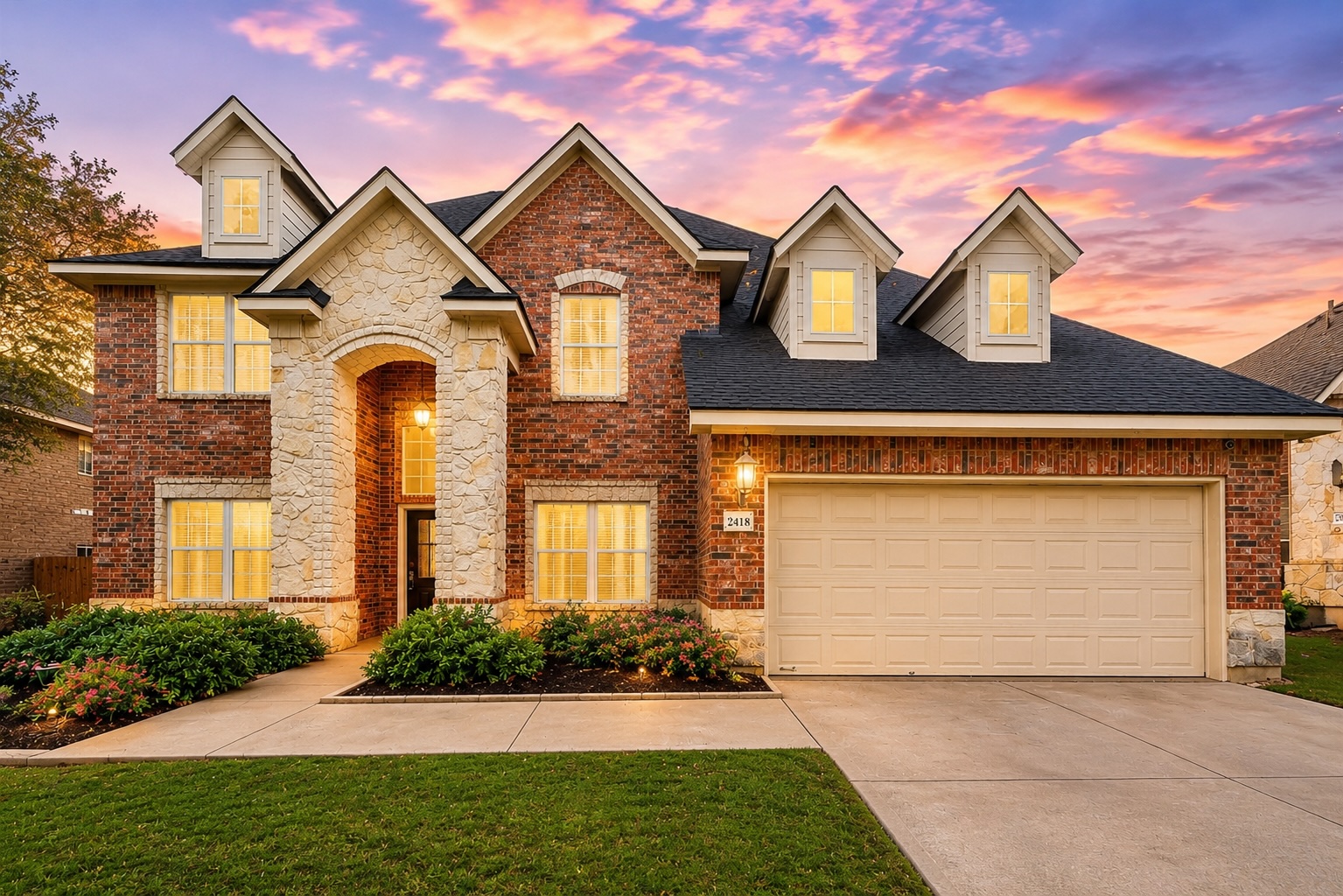 2415 Elkhorn Ranch Road Leander, TX 78641 - Photo 1 of 38 A classic brick and stone facade welcomes you to this stately residence under a vivid sunset sky.