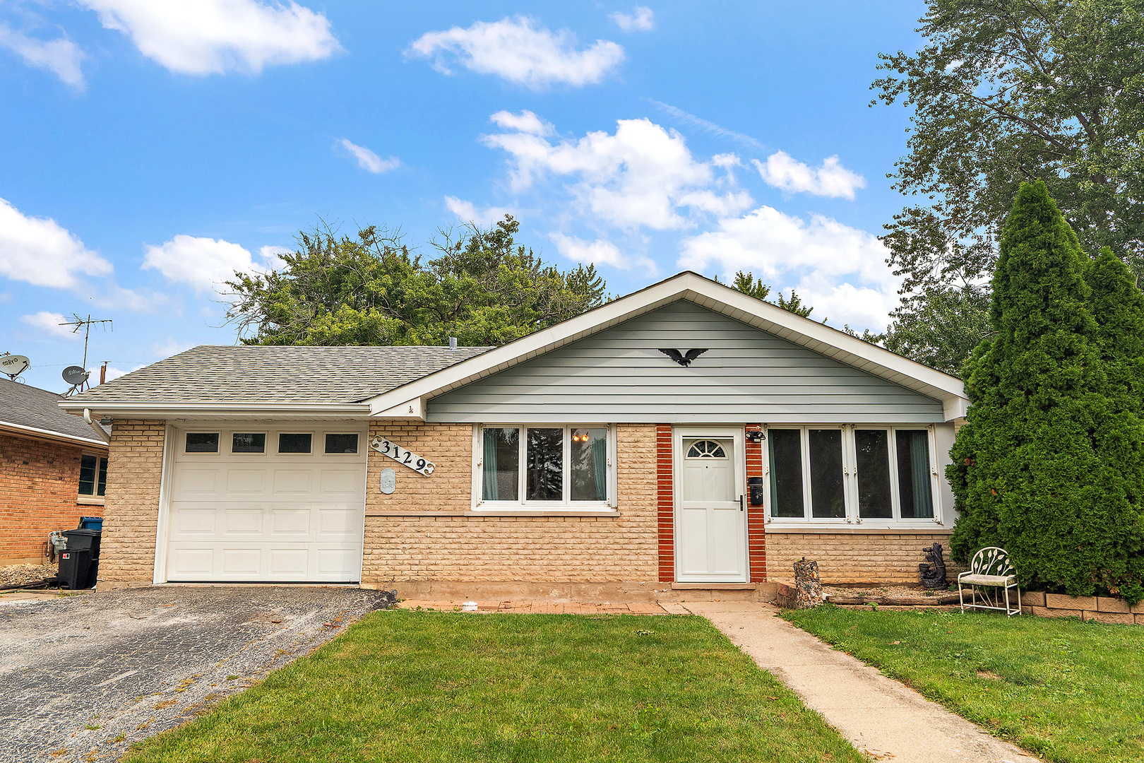 a front view of a house with a garden and yard