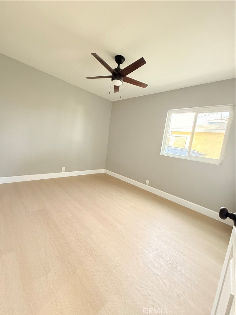 8803 Laurel Street Bellflower, CA 90706 - Photo 10 of 18 an empty room with windows and fan