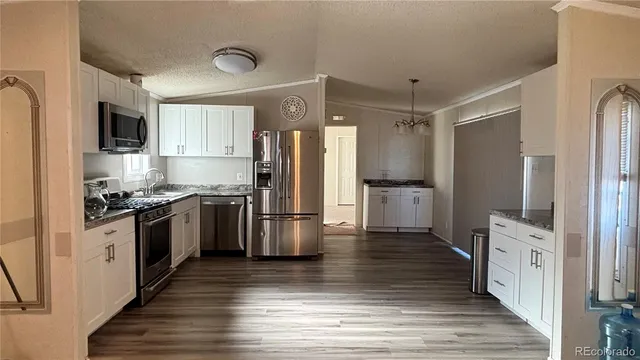 a kitchen with stainless steel appliances a refrigerator and a stove top oven