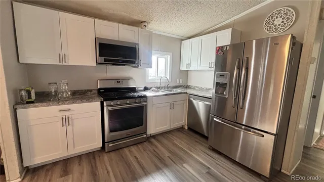 a kitchen with a refrigerator stove and white cabinets
