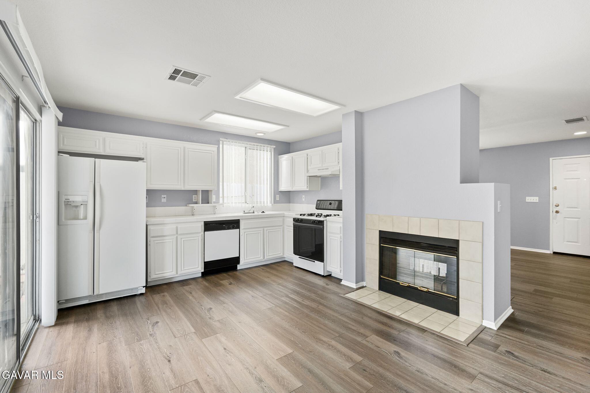 2108 Manchester Street Rosamond, CA 93560 - Photo 17 of 41 a kitchen with a white cabinets and a fireplace