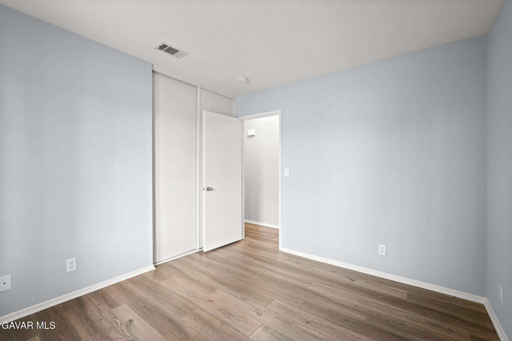 2108 Manchester Street Rosamond, CA 93560 - Photo 23 of 41 a view of an empty room with wooden floor